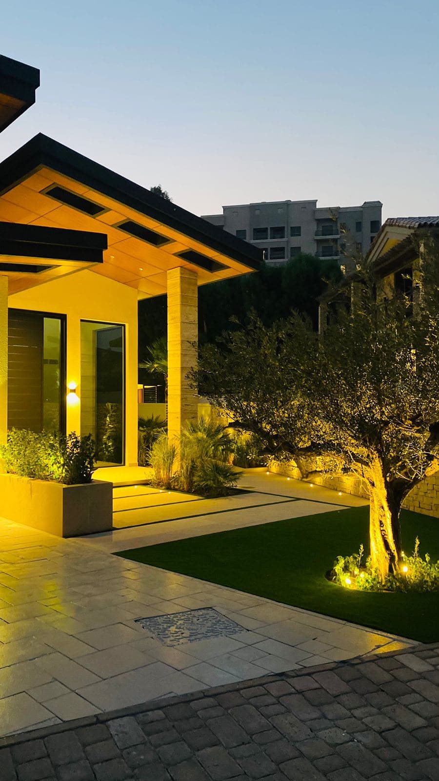 Villa entrance facade with warm architectural lighting at dusk