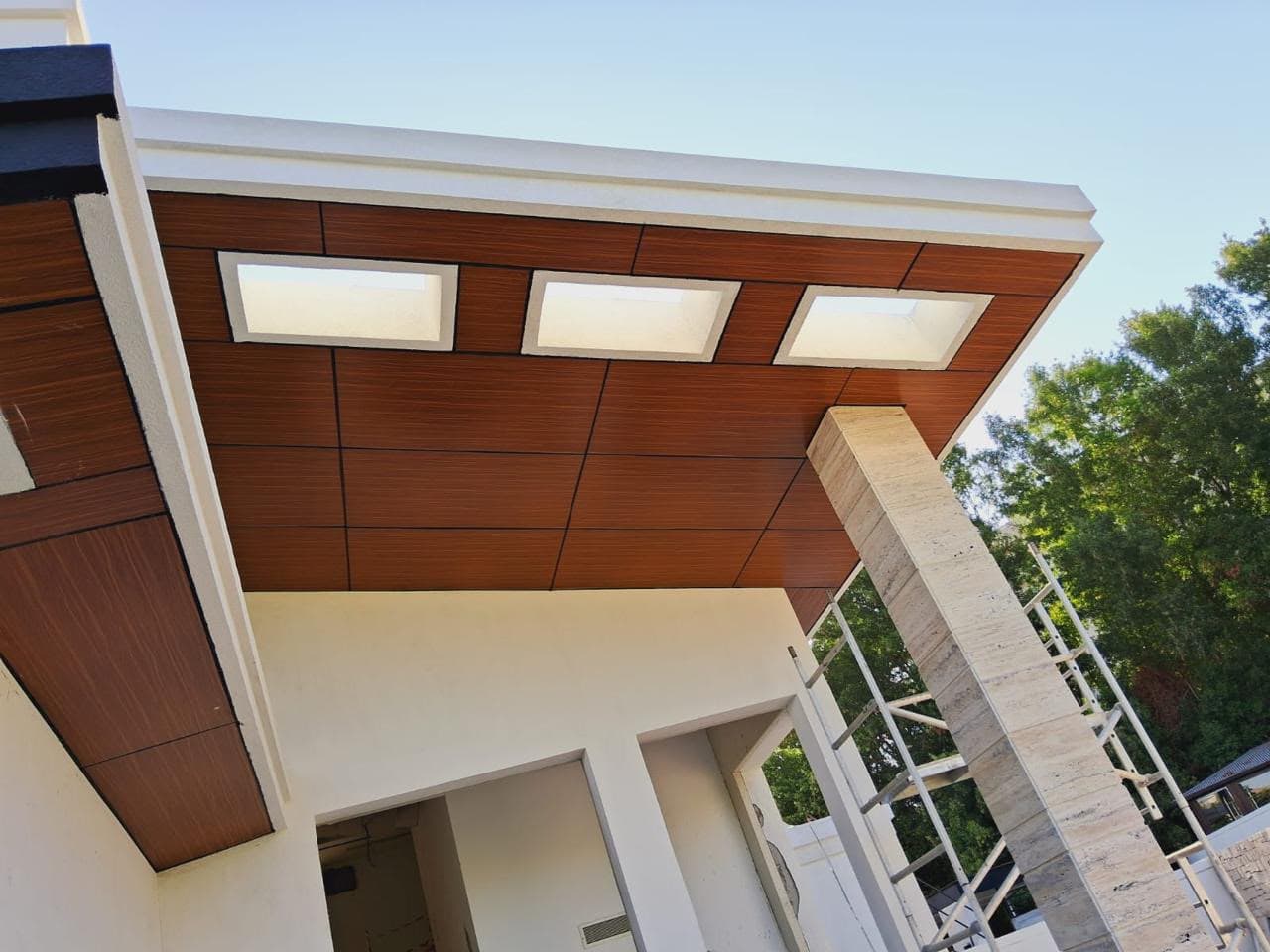 Close-up of a wood-finish aluminium composite facade panel installation