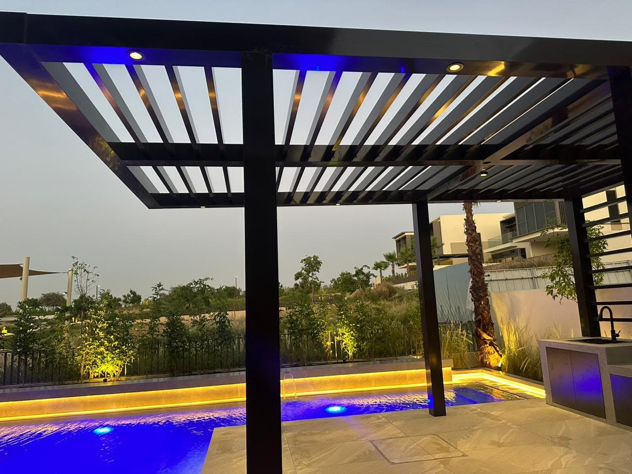 Aluminium pergola over a pool with an integrated outdoor kitchen